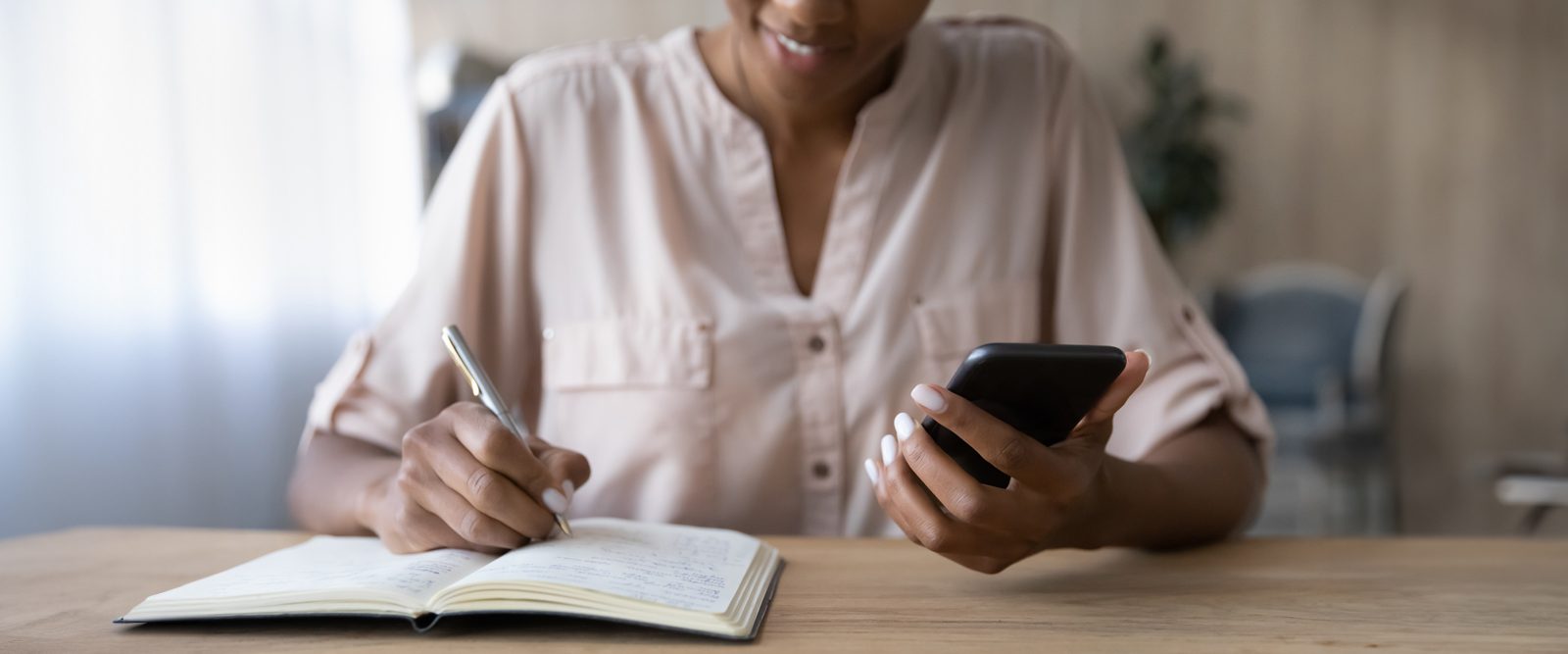 woman writing down from phone
