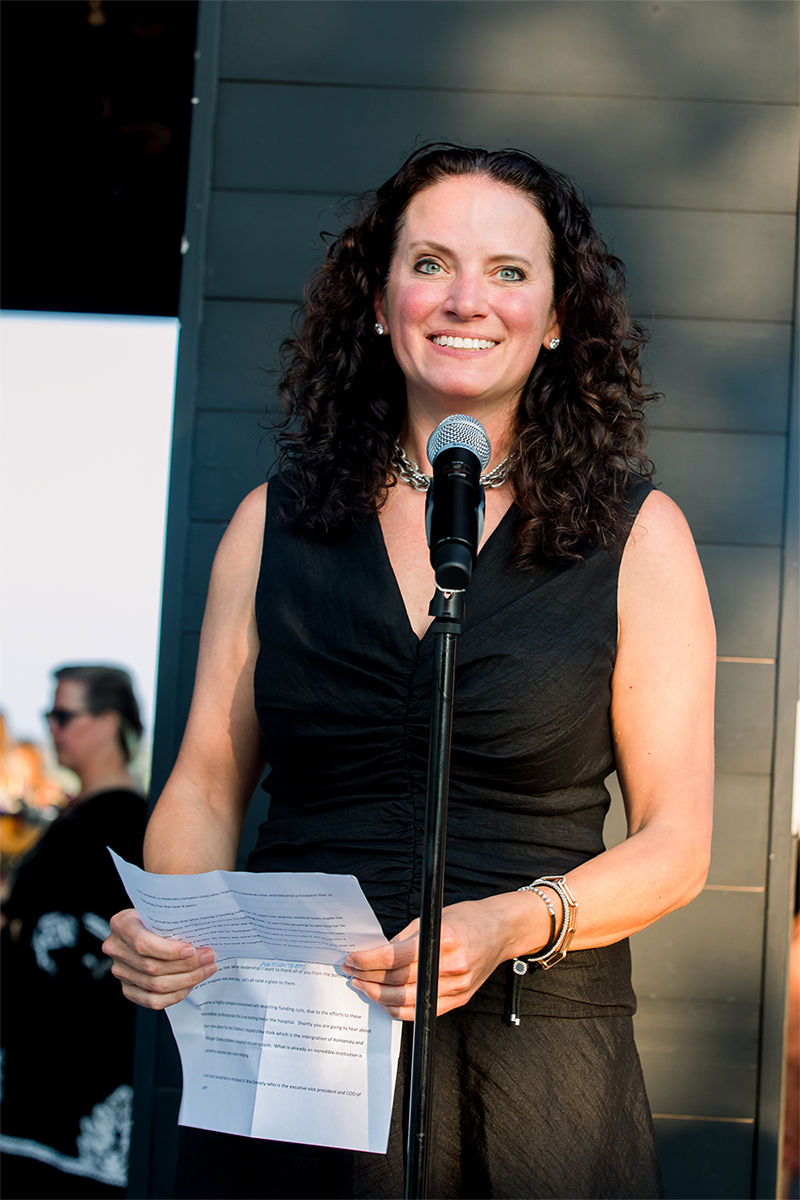 Woman standing at a microphone.