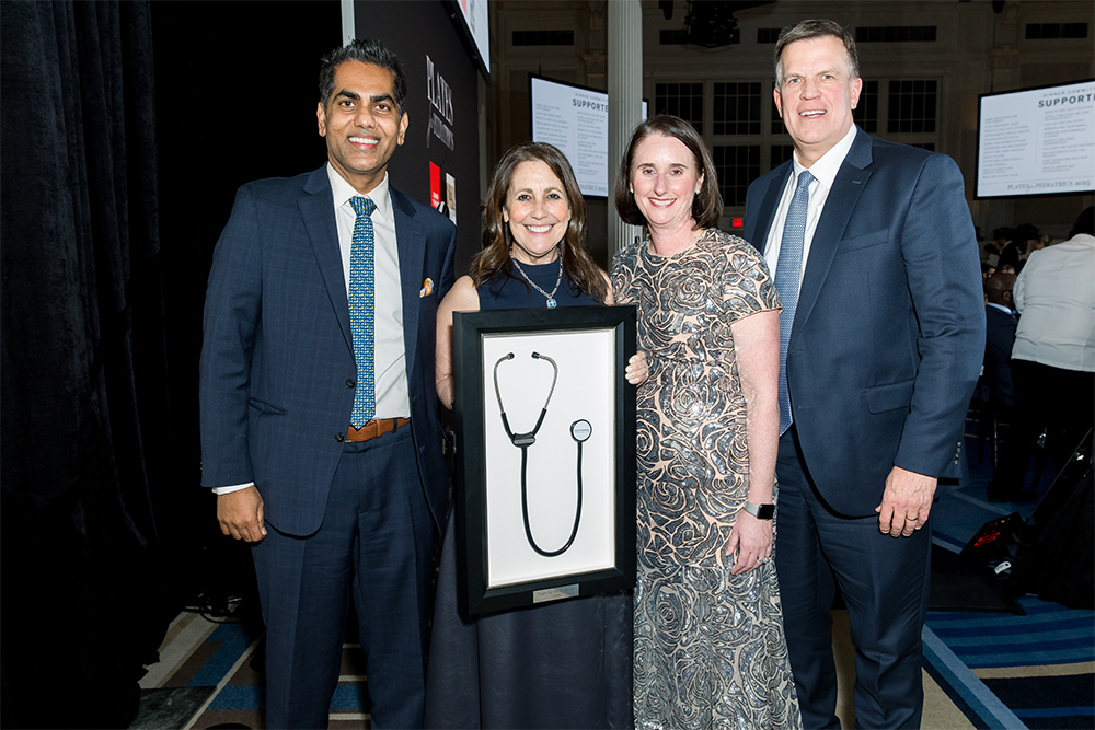 Small group standing with a print of a stethoscope.