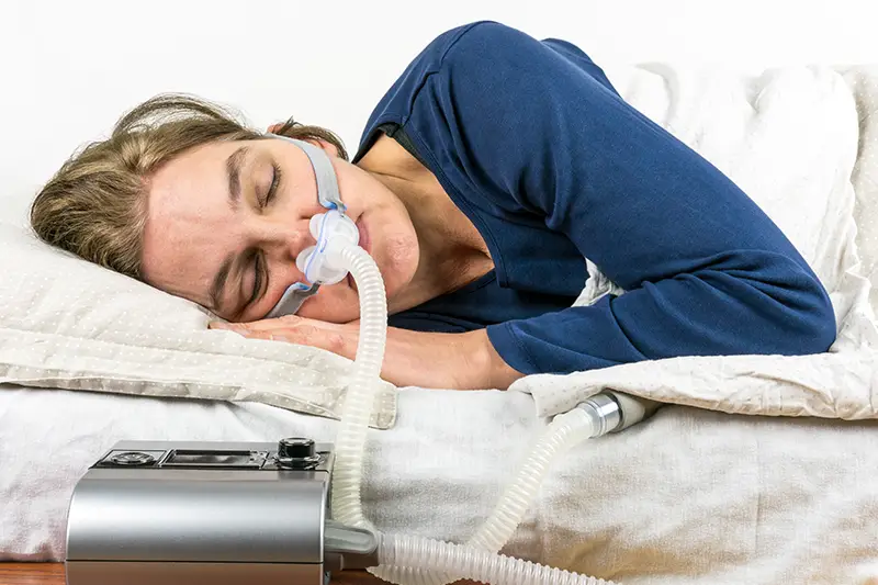 image of woman using CPAP machine