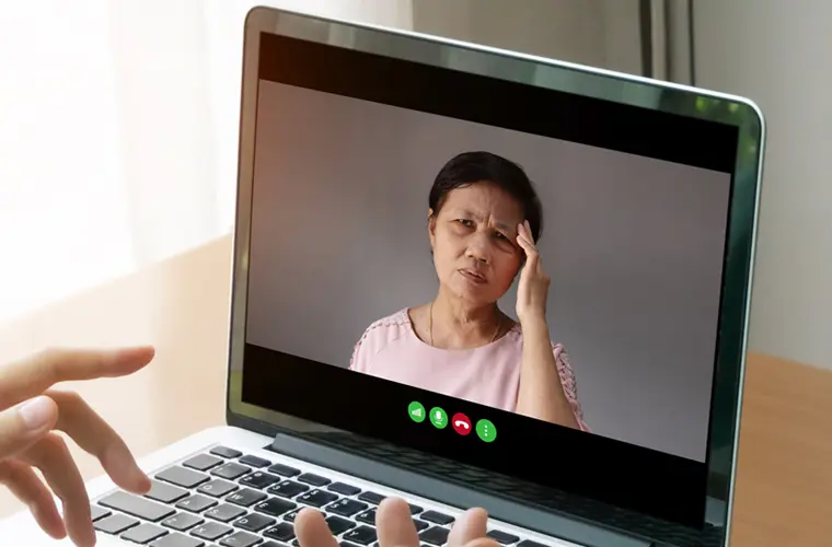 lady on a video visit holding her head